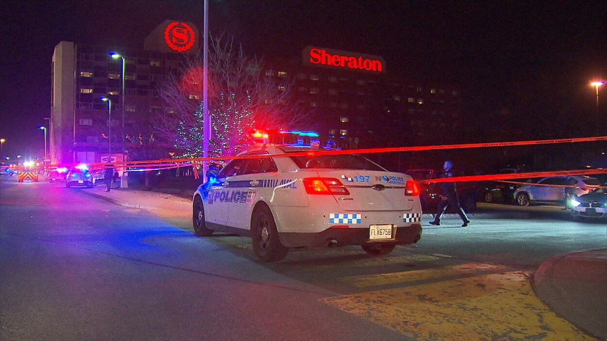 Une voiture de police est stationnée près d'un périmètre de sécurité à l'hôtel Sheraton.