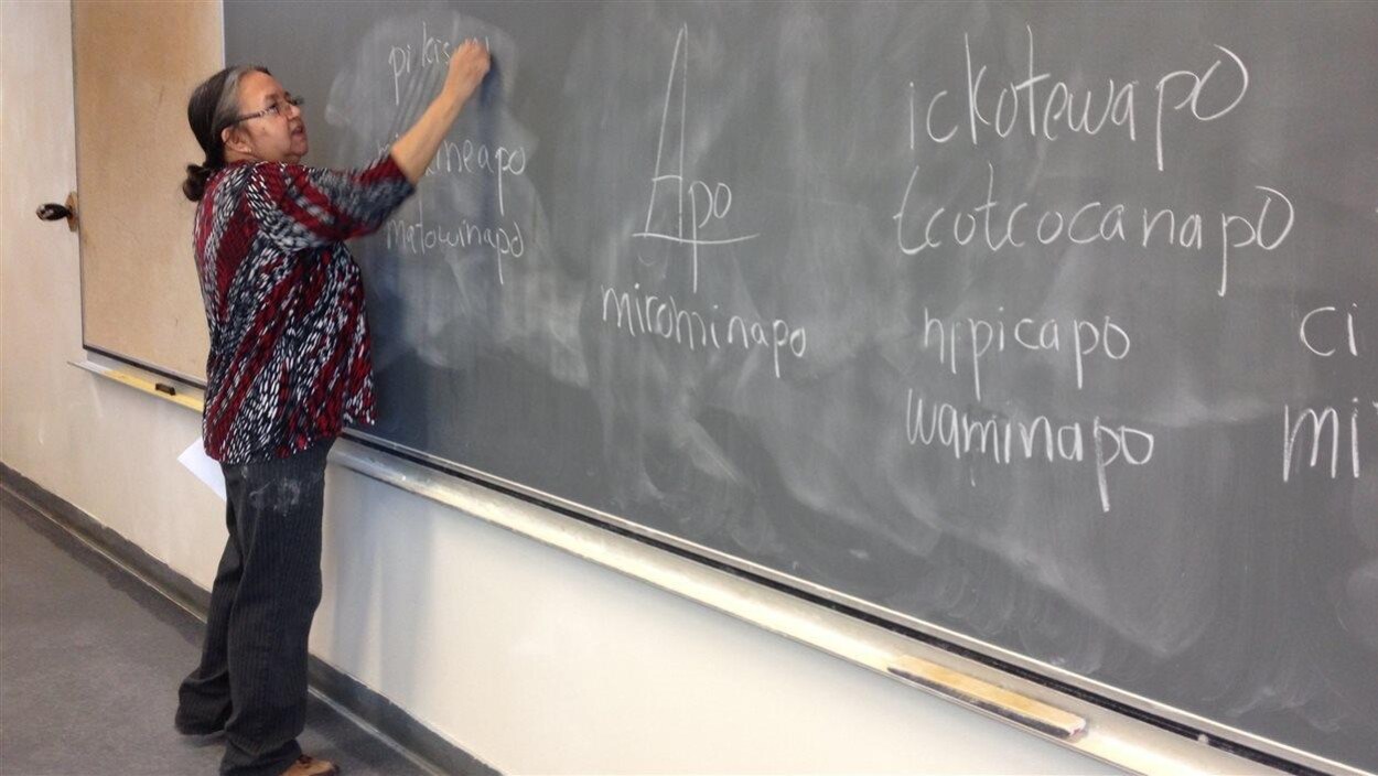 Une enseignante autochtone écrit sur un tableau.