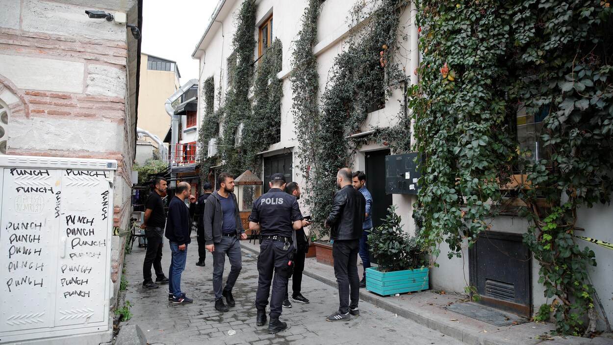 Des policiers et des civils dans une ruelle.