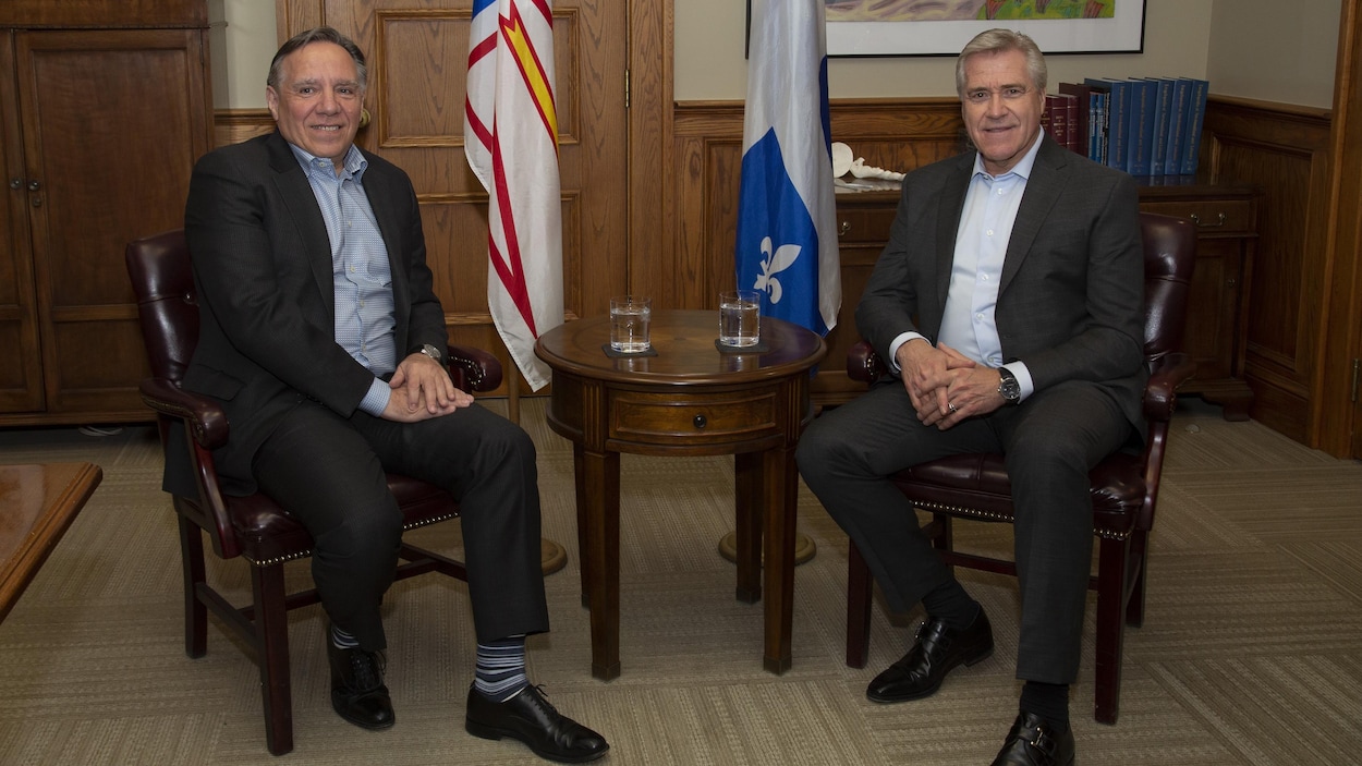 François Legault et Dwight Ball assis ensemble lors d'une rencontre devant la presse à Saint-Jean.