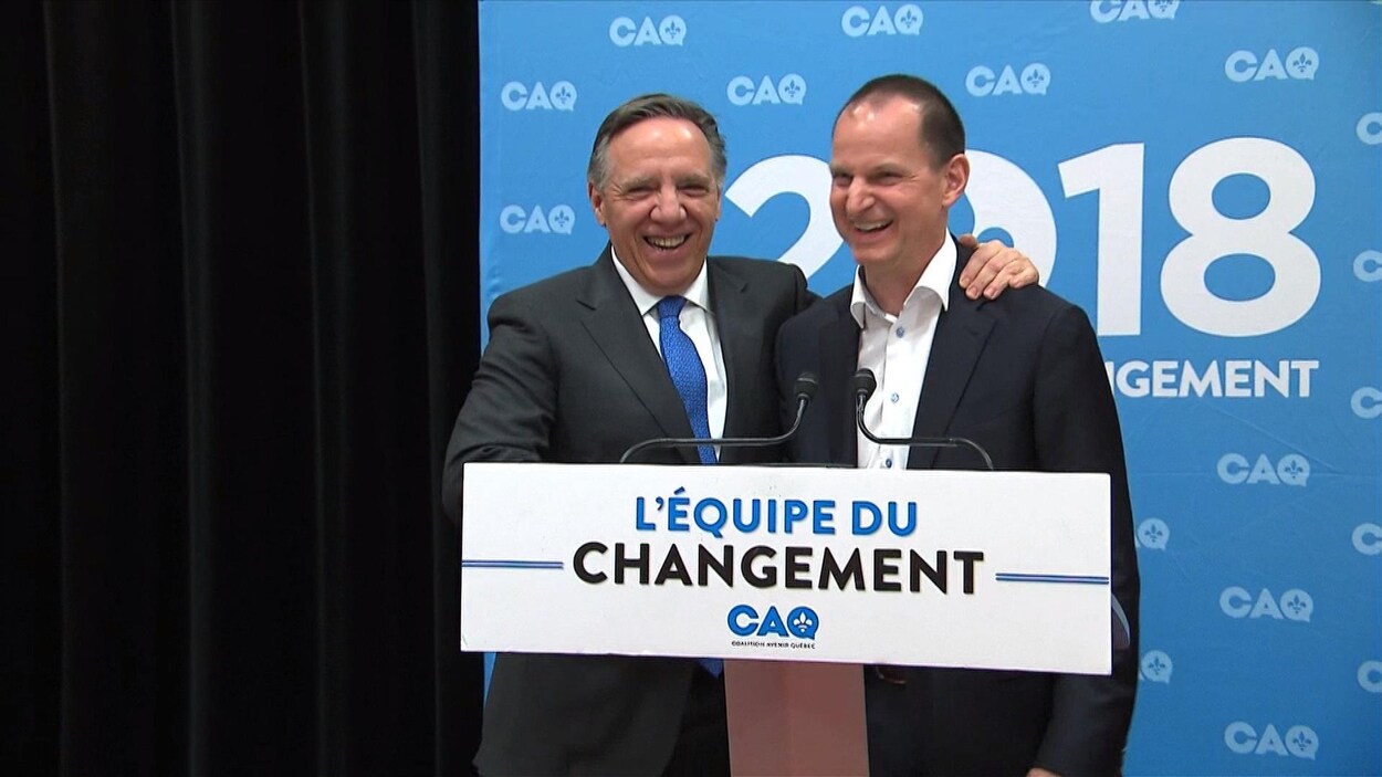 Le chef de la Coalition avenir Québec, François Legault, sourit et met sa main sur l'épaule de son candidat dans la circonscription de Groulx, l'économiste Éric Girard.