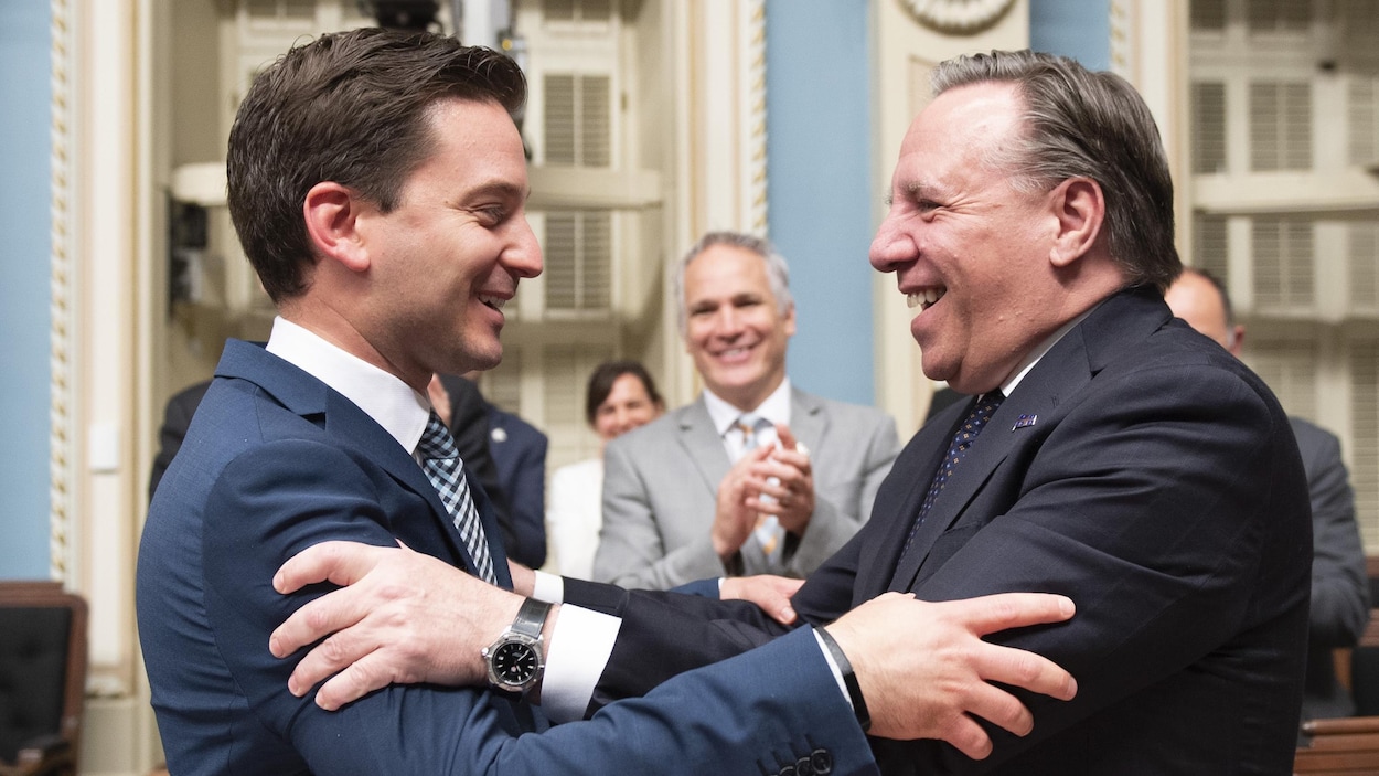 Le ministre de l'Immigration et leader parlementaire de la CAQ, Simon Jolin-Barrette, et le premier ministre François Legault se félicitent de l'adoption du PL 21, dimanche soir, au Salon bleu. 