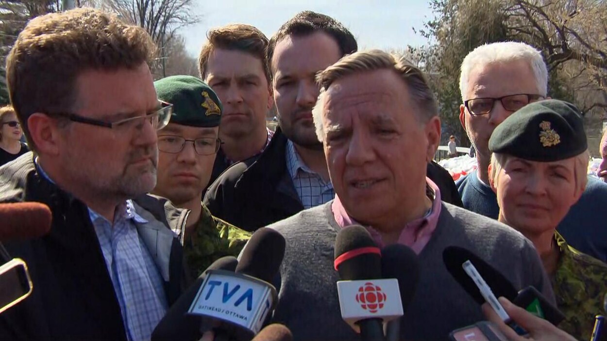 Messieurs Legault et Pednaud-Jobin répondent aux questions des journalistes, entourés de représentants du gouvernement québécois et des Forces armées canadiennes.