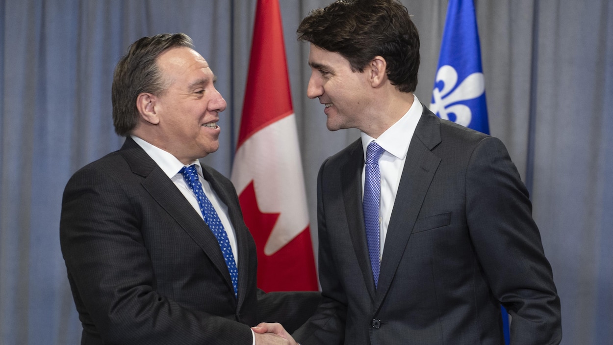 François Legault et Justin se serrent la main.