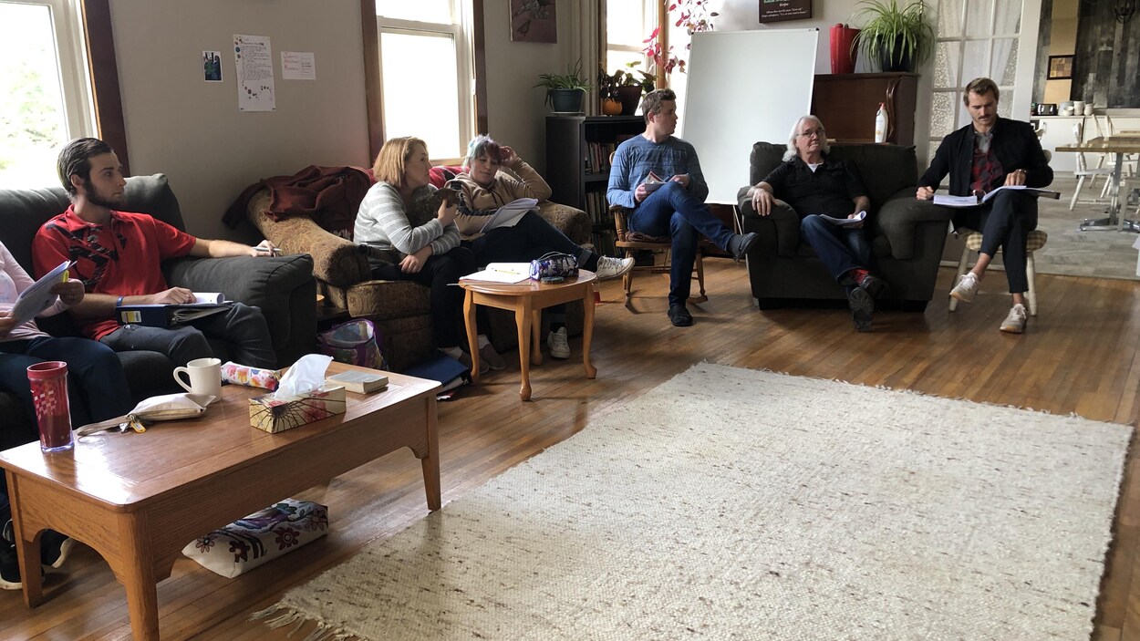 Des résidents participent à une thérapie de groupe dans le salon de la Lennon House.