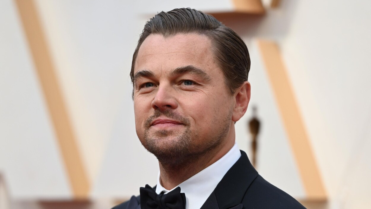 Leonardo DiCaprio, portant un complet, sur le tapis rouge d'une soirée des Oscars.