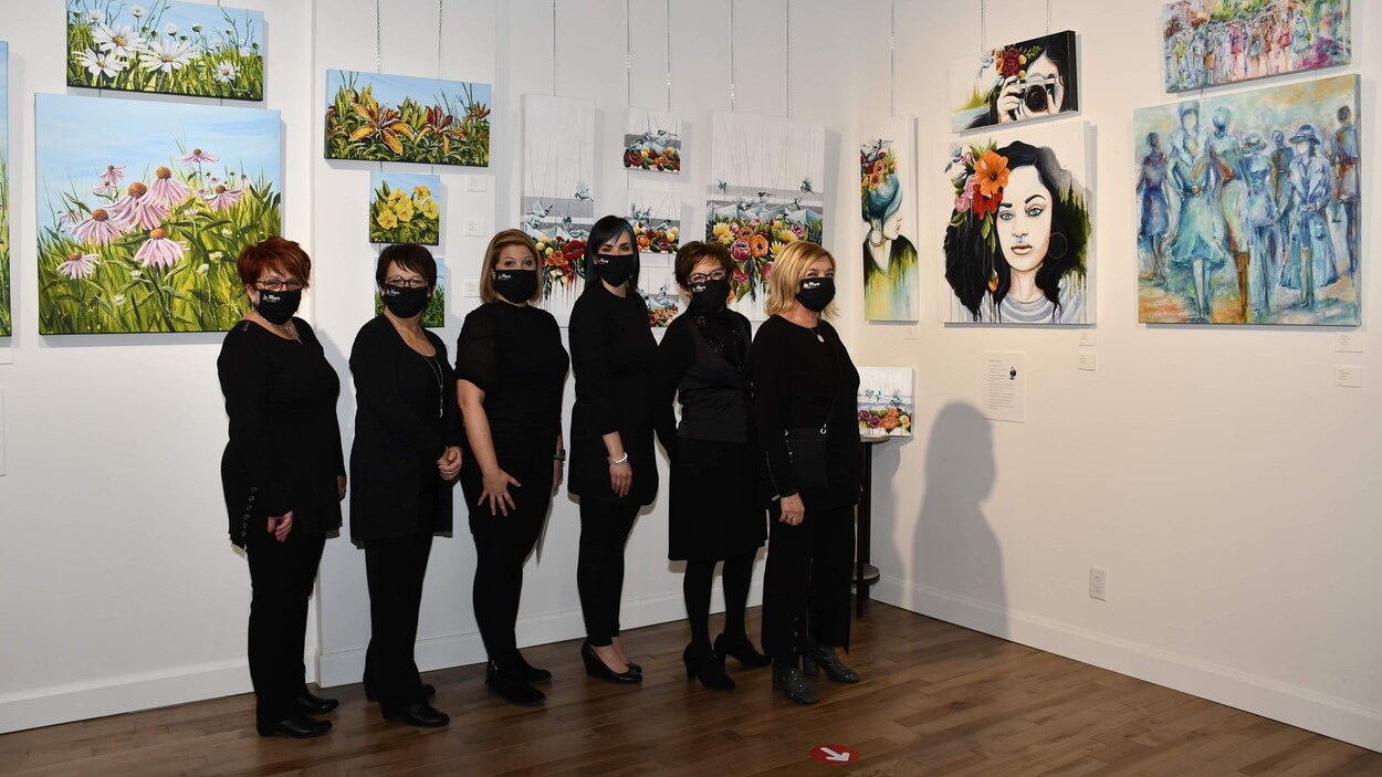 Cinq femmes qui posent pour une photo devant leurs oeuvres.