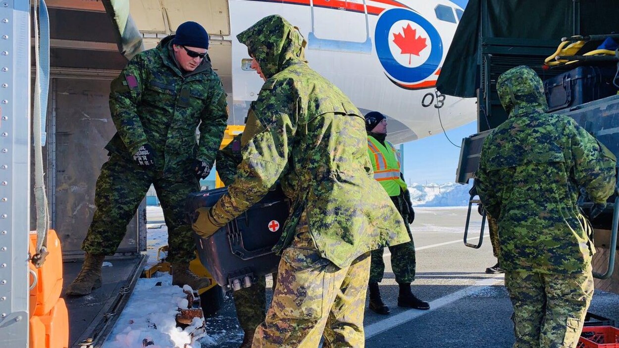 Des troupes des Forces armées canadiennes montent dans un avion.