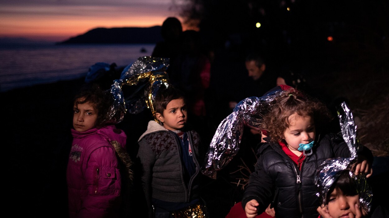 Des enfants migrants sur la plage le soir.