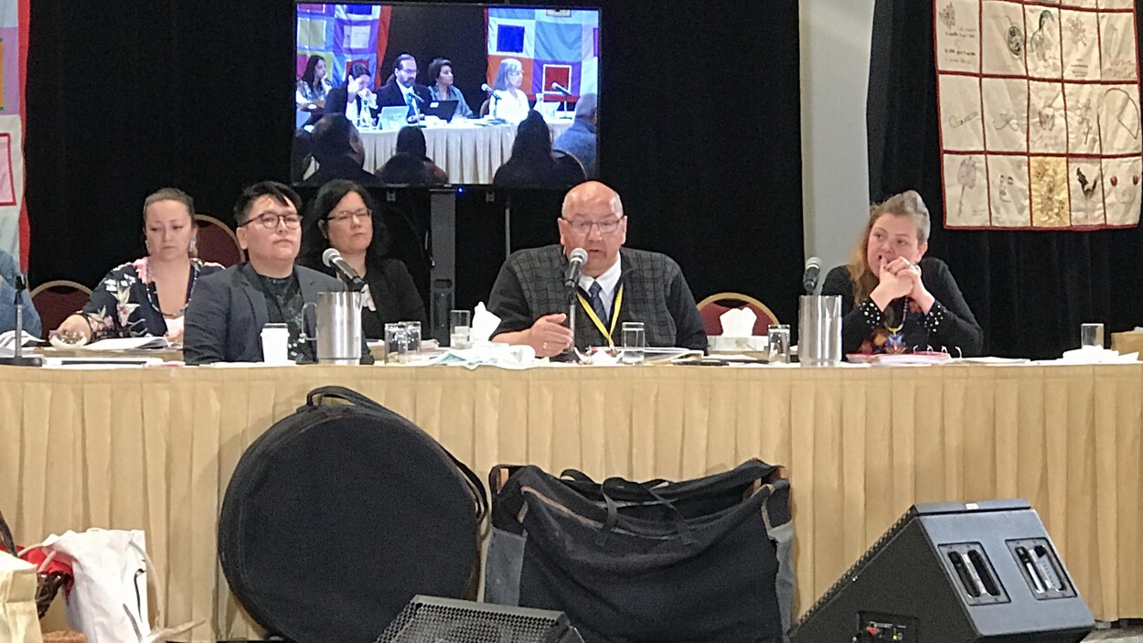 Trois personnes sont assises à une table. Trois personnes sont assises à une table.
