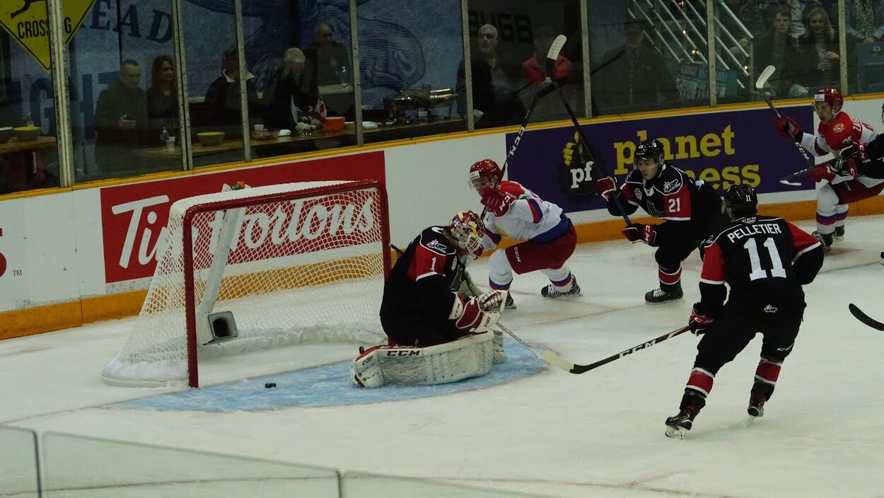 Une mêlée de hockeyeurs devant le filet du Canada où vient d'entrer la rondelle.