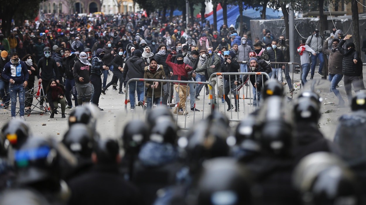 De nombreux manifestants sont séparés des forces de l'ordre par quelques mètres. Plusieurs lancent des projectiles en leur direction.