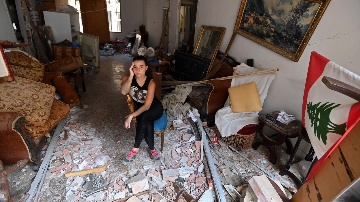 Une femme est assise au milieu des décombres de sa maison endommagée dans la capitale libanaise, Beyrouth, le 6 août 2020, deux jours après qu'une explosion massive ait secoué la ville.