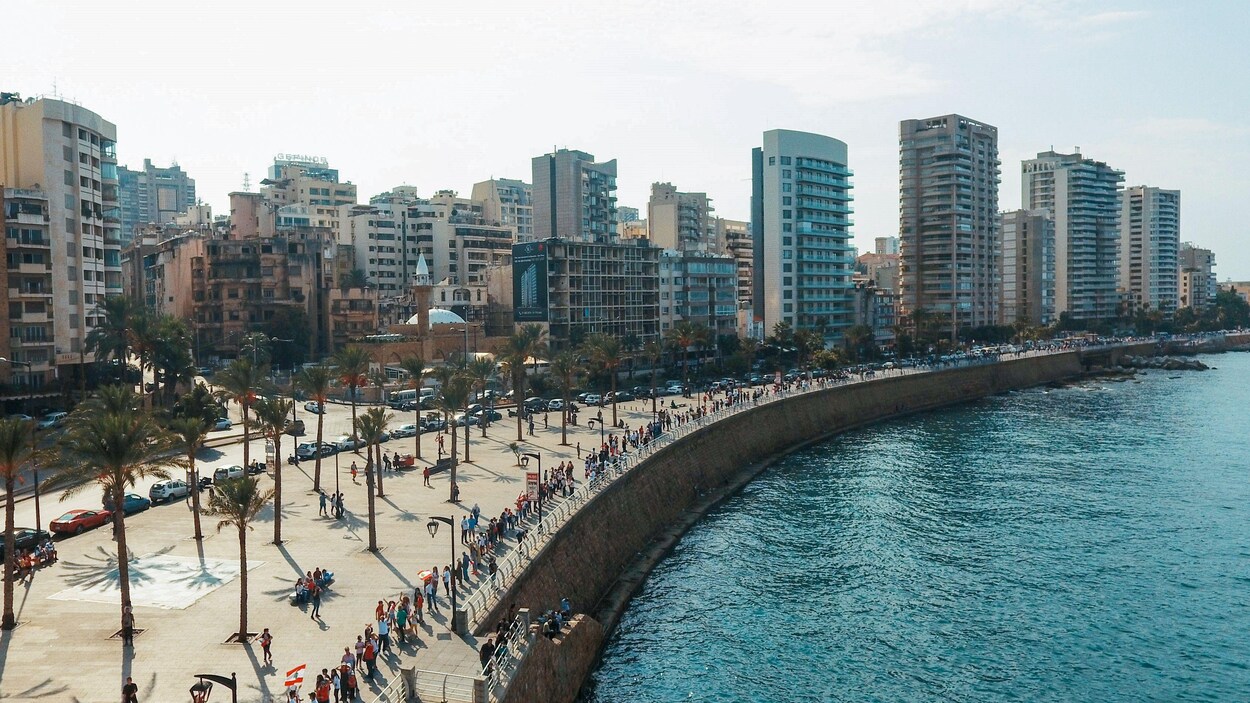 Une photo aérienne montre une file de milliers de personnes se tenant par la main, le long d'un quai qui borde la Méditerranée à Beyrouth, au Liban.