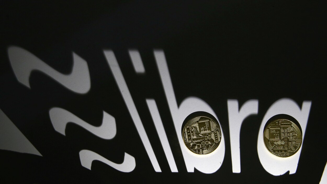 Des pièces de monnaie illustrant le concept de cryptomonnaie sont déposées sur le logo du projet Libra.