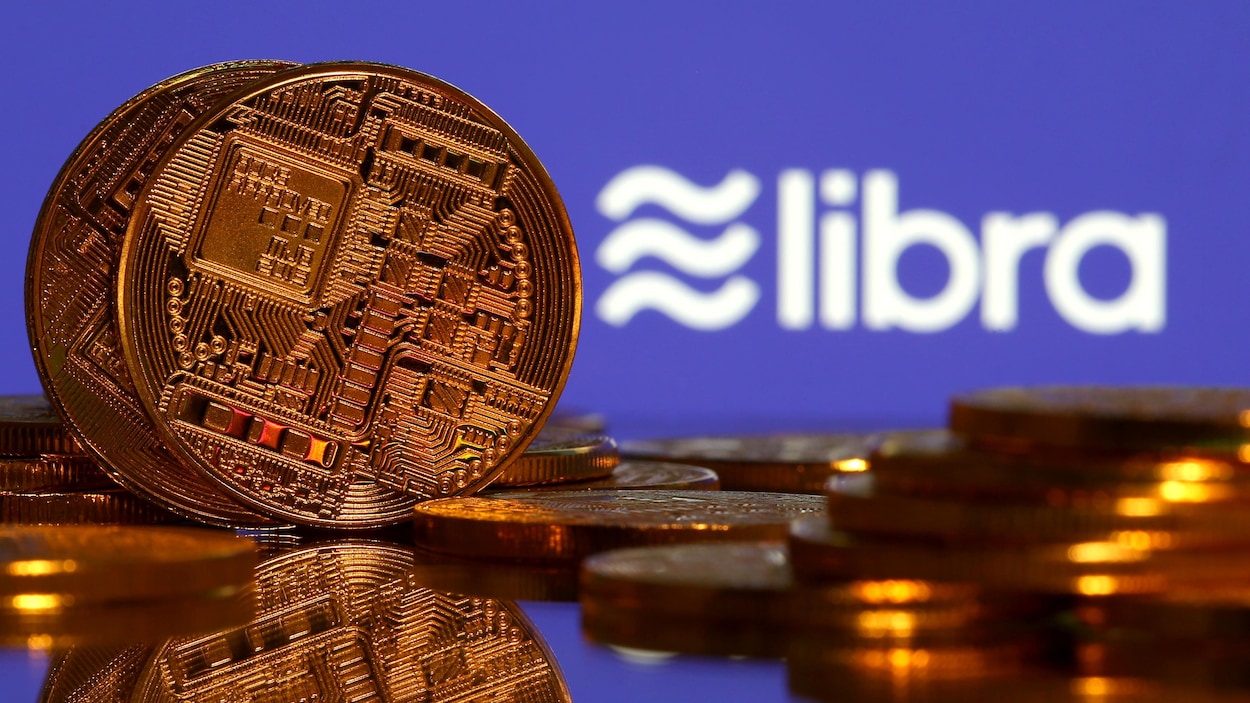 Pièces de monnaie placées devant un écran où il est écrit « libra ».