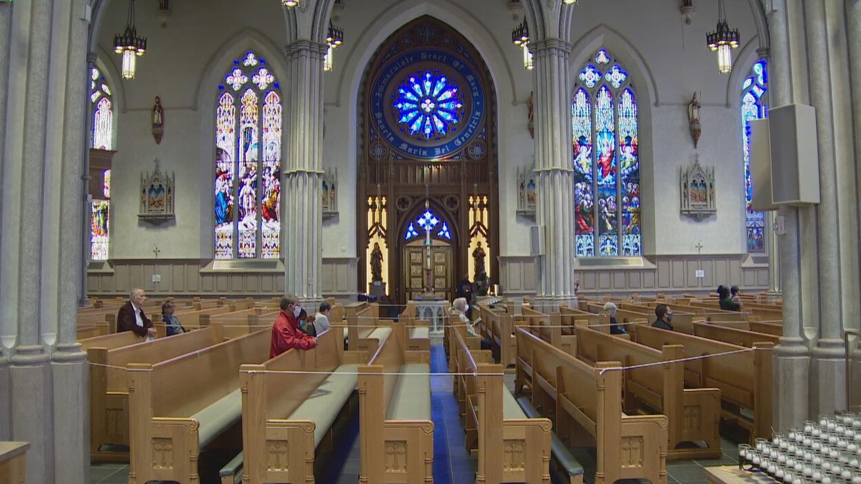 Des fidèles prient avec des masques à l'intérieur de la cathédrale St. Michael's à Toronto.