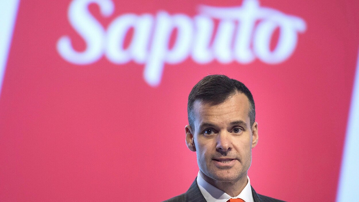 Lino Saputo fils devant un mur rouge et le logo de la compagnie Saputo.
