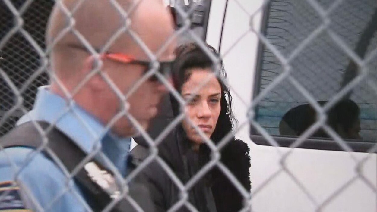 Lison Asselin est escortée par un constable spécial à son arrivée au palais de justice de La Malbaie.