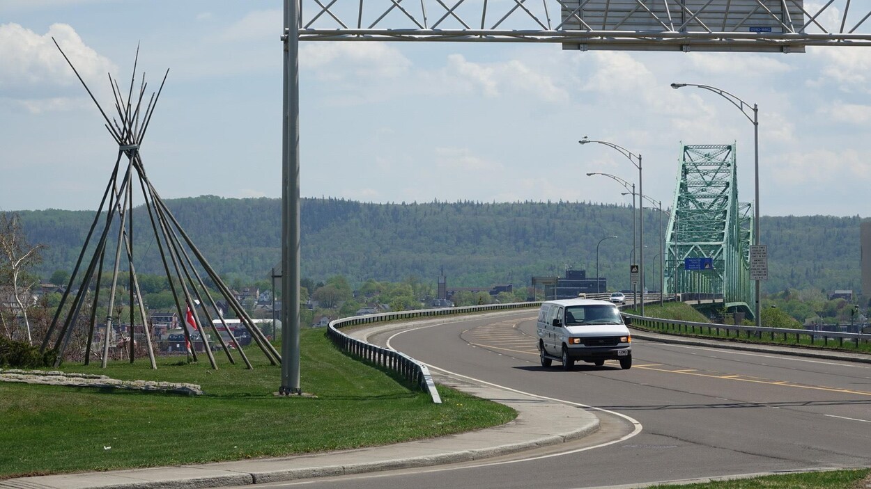 Une voiture vient de traverser le pont Van Horne. À gauche, le tipi traditionnel représentant Listuguj.