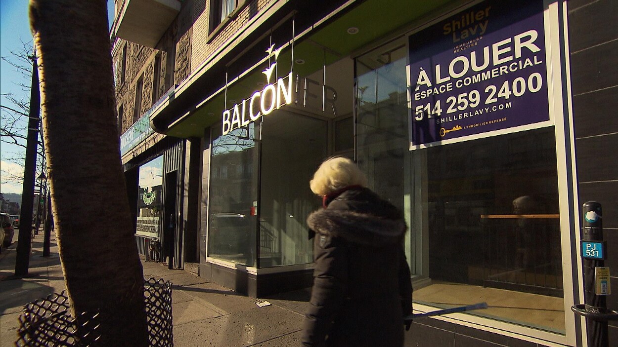 Une femme passe devant un local commercial vacant à Montréal.