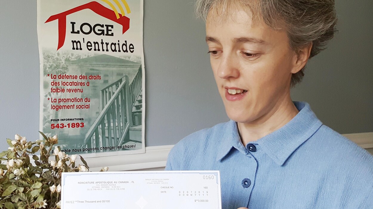 Sonia Côté tient un chèque envoyé par le pape François.