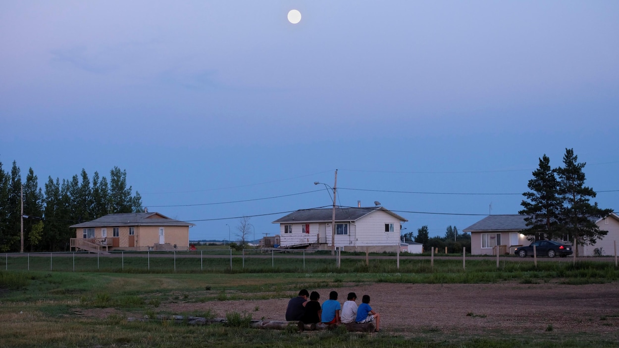 Des enfants de la Première Nation Cote sont assis sur un terrain de camping près de la ville de Kamsack dans la province de la Saskatchewan, le 6 août 2017.