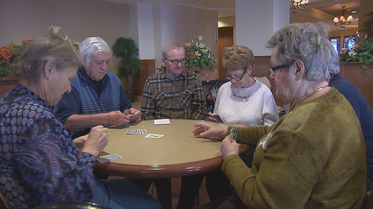 Des personnes âgées jouent aux cartes.