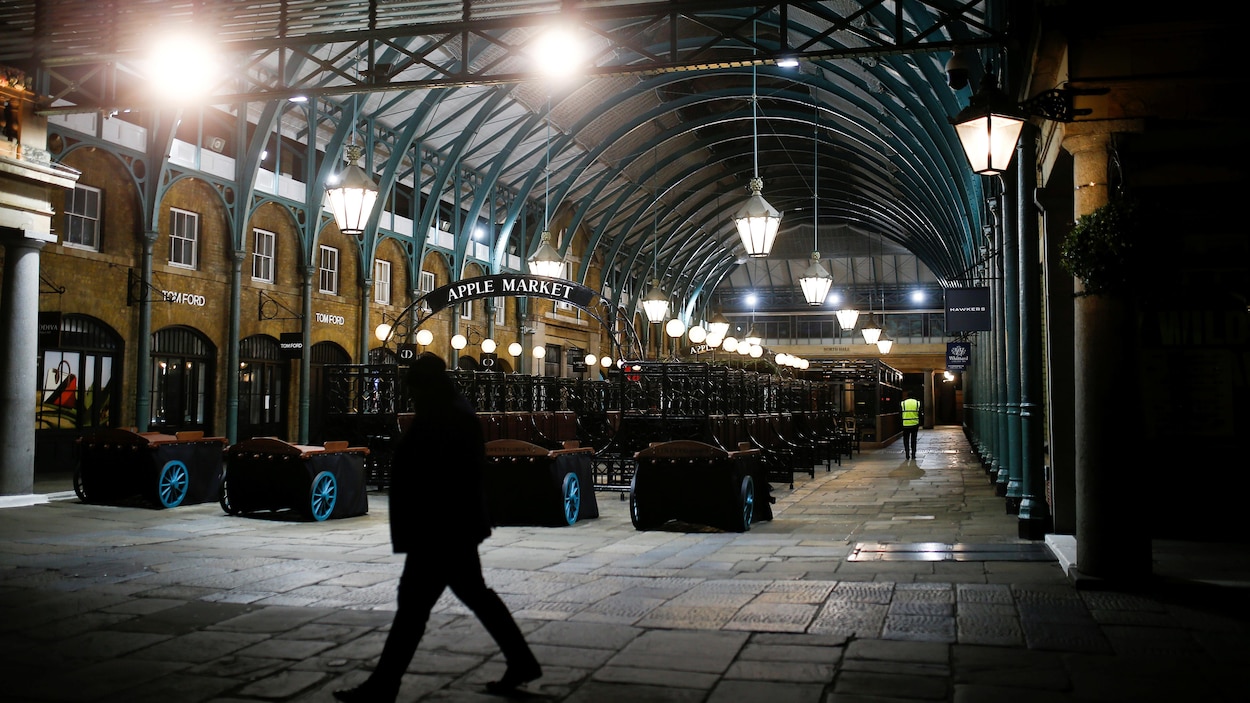 Un homme traverse Covent Garden à Londres.