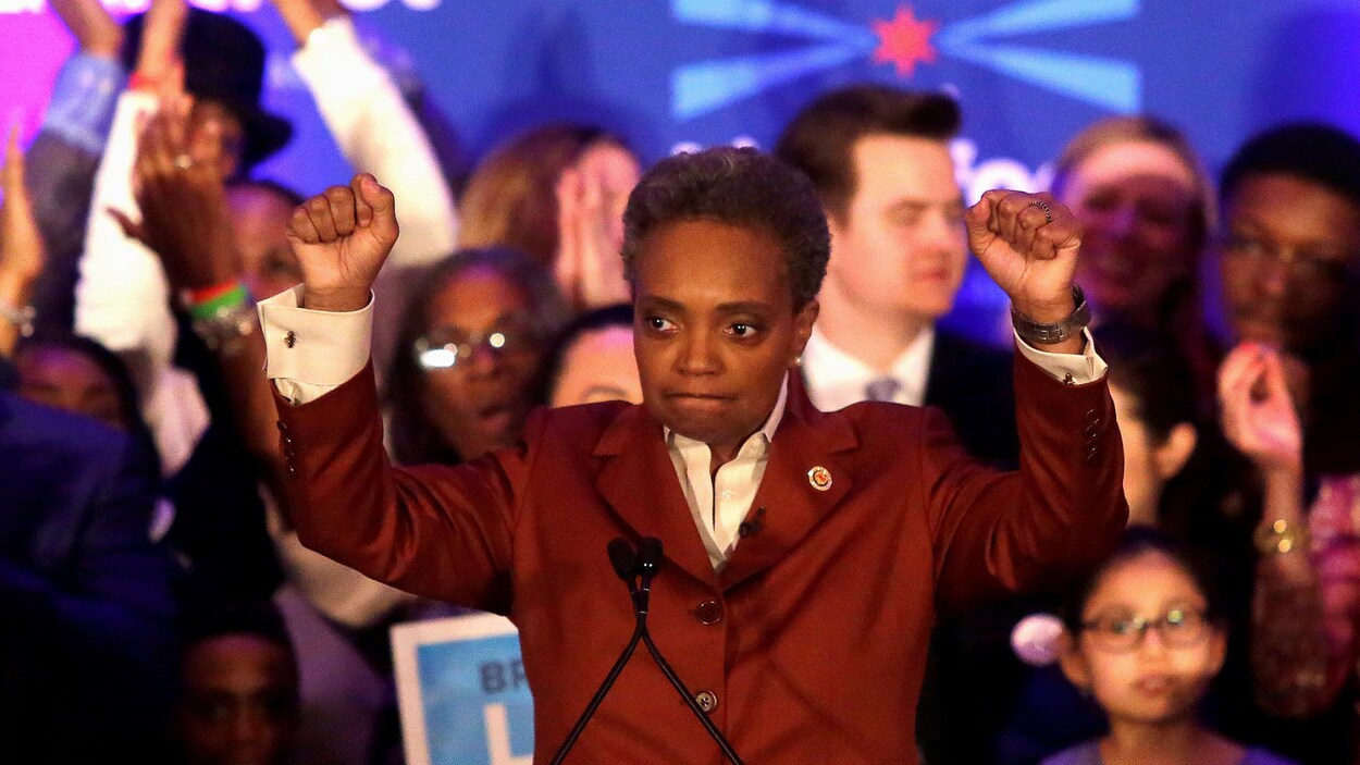 Lori Lightfoot lève les bras alors qu'elle s'adresse à ses militants.