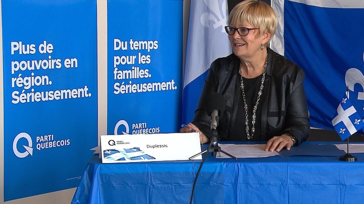 Lorraine Richard devant un drapeau du Québec et des pancartes électorales de son parti Lorraine Richard devant un drapeau du Québec et des pancartes électorales de son parti