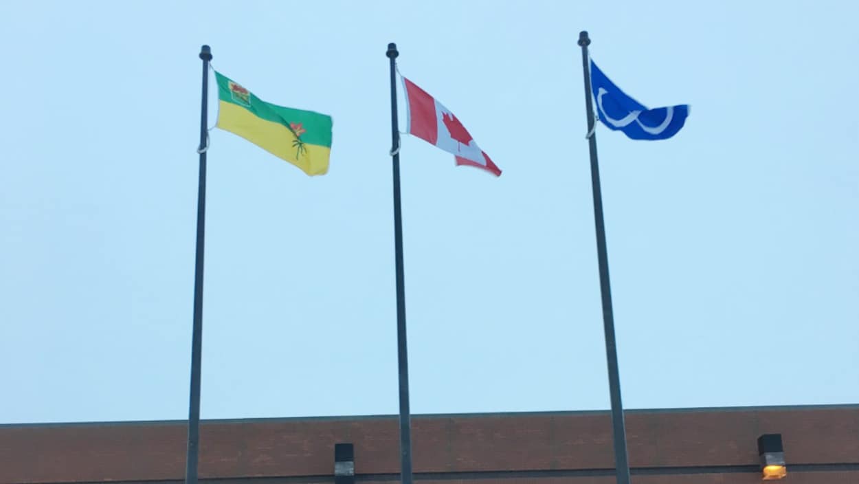 Trois drapeaux en plein coeur devant le quartier général de la GRC en hommage à Louis Riel.