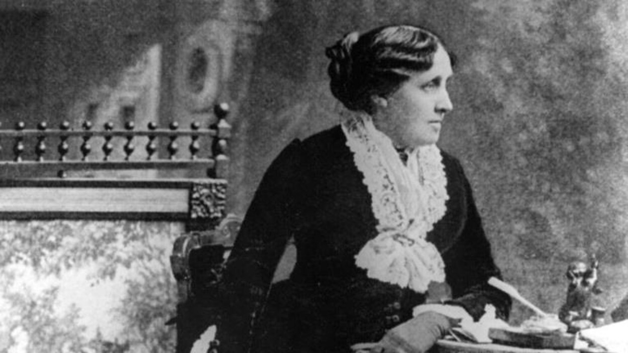 Portrait en noir et blanc, et de profil, de Louisa May Alcott, qui porte un chignon.