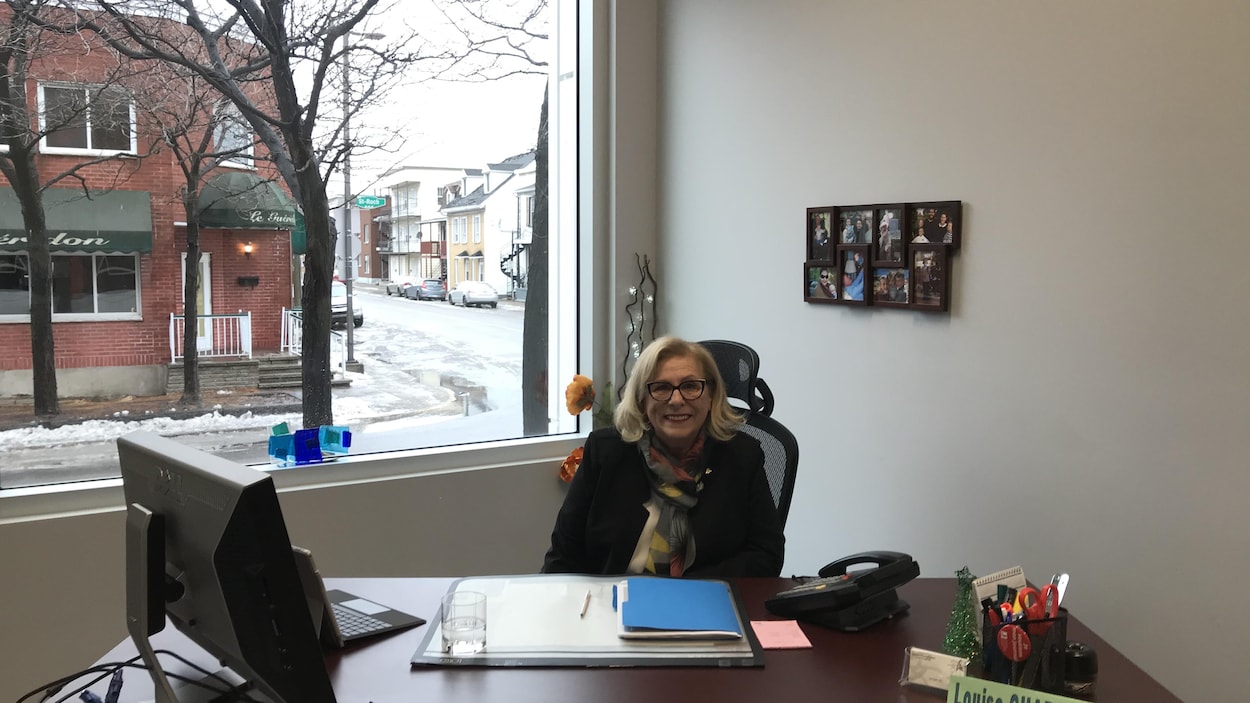 La nouvelle députée fédérale de Trois-Rivières, Louise Charbonneau, assise derrière son bureau, avec un écriteau où son nom est inscrit.