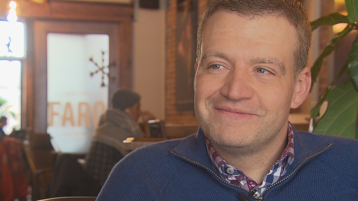 Luc Fortin est assis dans un café