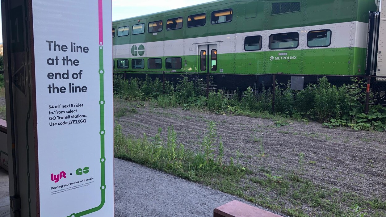 On voit une voiture du train Go un panneau du nouveau programme