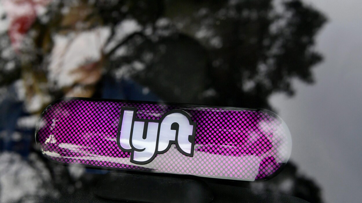 Une enseigne lumineuse de la compagnie Lyft sur le tableau de bord d'une voiture. Une enseigne lumineuse de la compagnie Lyft sur le tableau de bord d'une voiture.
