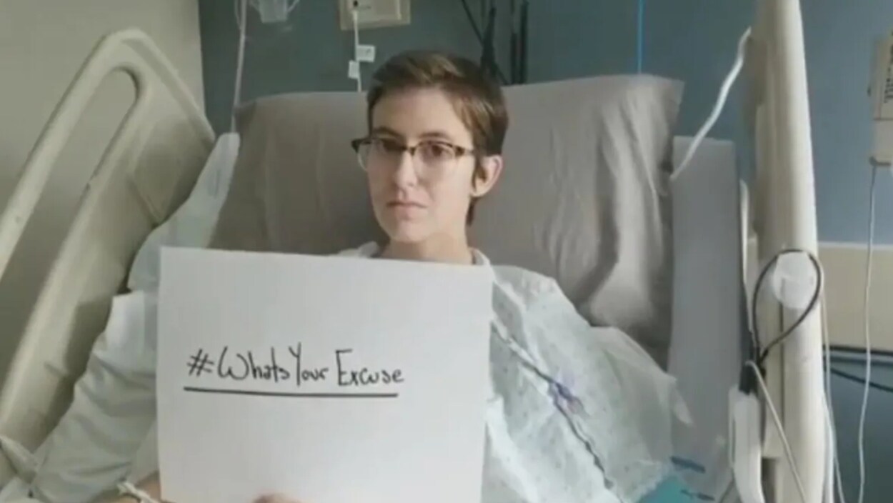 Maddison Yetman est dans son lit d'hôpital. Elle tient entre ses mains un carton blanc où est écrit #WhatsYourExcuse.