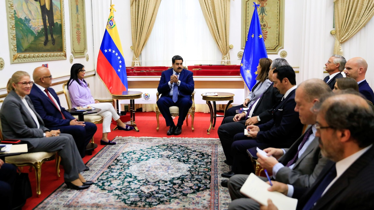 Nicolas Maduro, assis sur un fauteuil doré, est au centre de deux rangées de diplomates aussi assis dans une pièce du palais présidentiel de Caracas. Un drapeau du Venezuela et un de l'Union européenne sont accrochés.