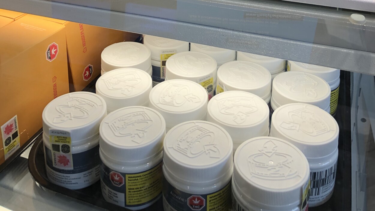 Un étalage contenant des pots de cannabis avec une pancarte parlant des produits comestibles de cannabis.