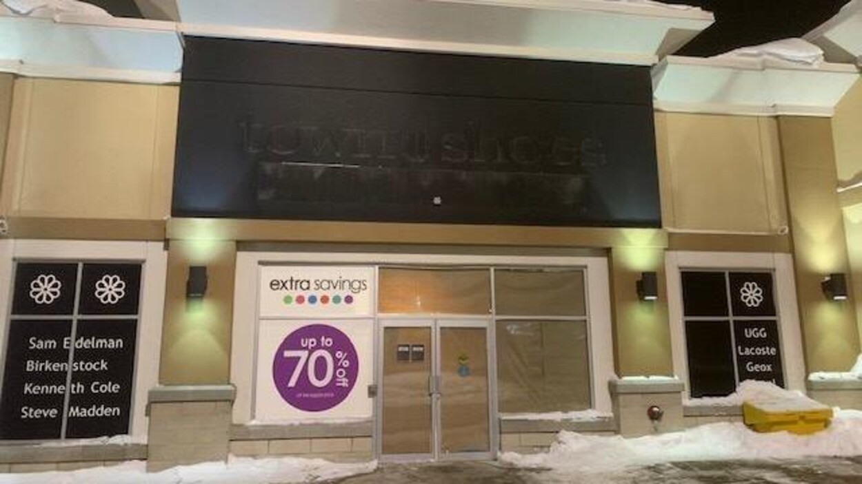 Devanture d’un ancien magasin de souliers, le soir.