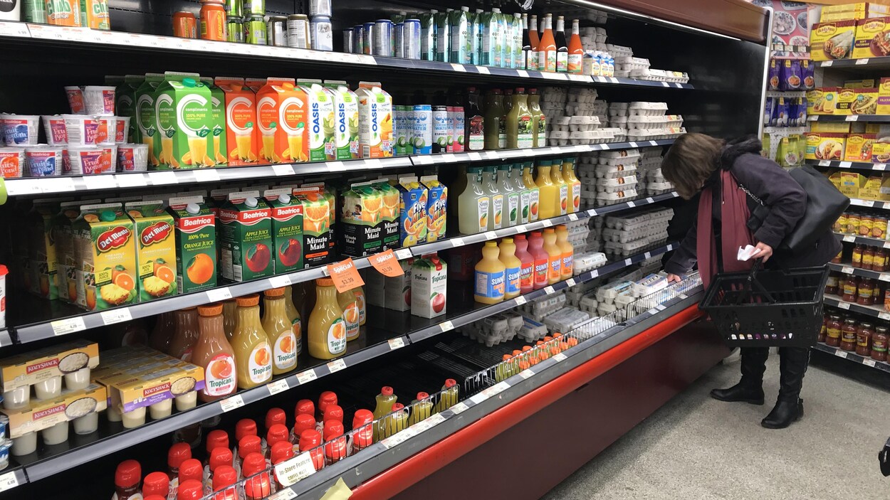 Un rayon frais d'épicerie où se trouvent différents jus de fruits et des oeufs.