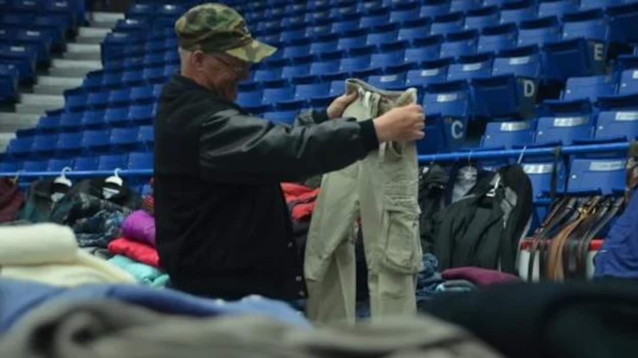 Un homme qui regarde une paire de pantalons