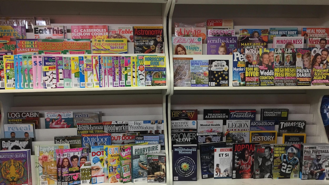 Des étagères de magazines dans un commerce.