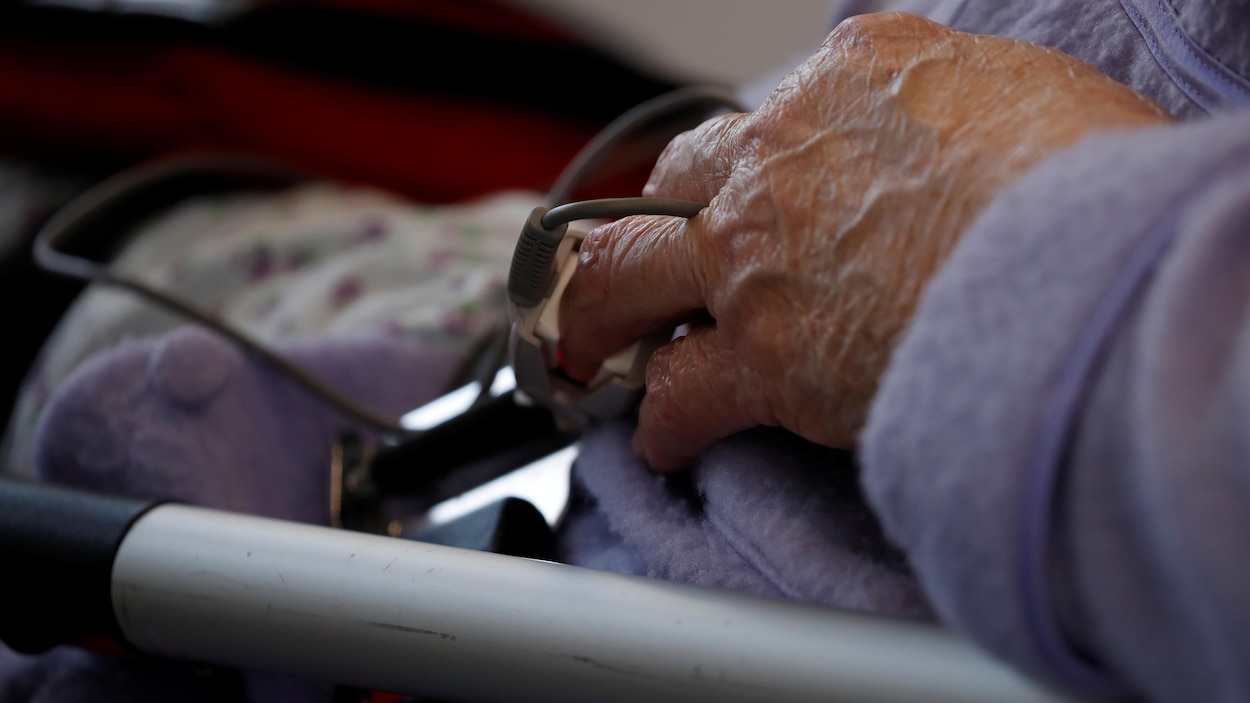 Le doigt de la patiente est enserré dans un dispositif qui mesure les signes vitaux.