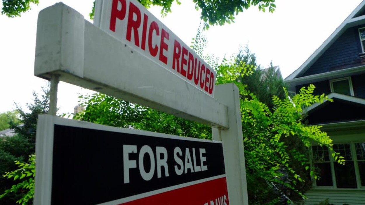 Panneau à vendre devant une maison.