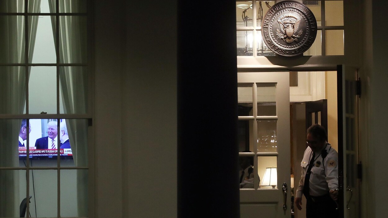 Un agent de la sécurité de la Maison-Blanche ferme une porte. Par une fenêtre, on peut voir une télévision ouverte. Un agent de la sécurité de la Maison-Blanche ferme une porte. Par une fenêtre, on peut voir une télévision ouverte.