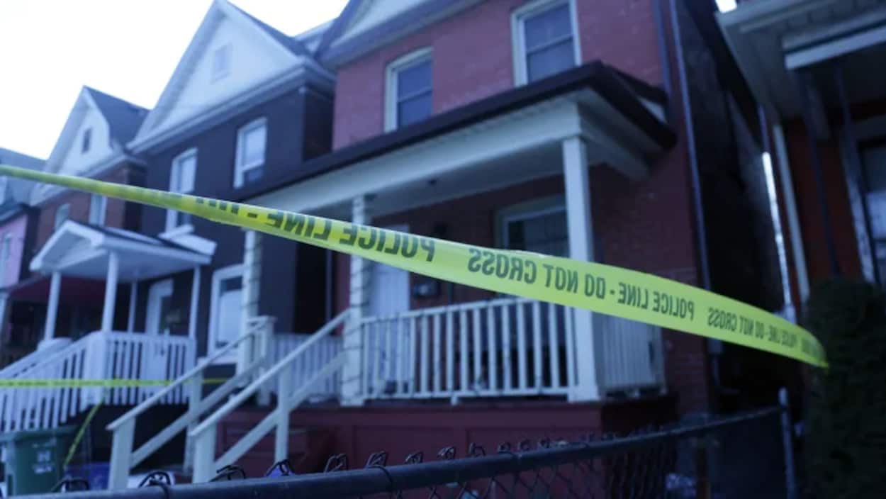 Des maisons résidentielles avec un bandeau de la police devant.