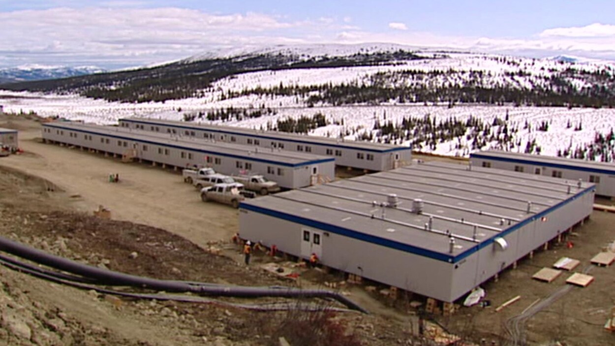 Des maisons mobiles de la mine Wolverine au Yukon vues depuis le sommet d'une colline avec au loin des arbres sous la neige. Des maisons mobiles de la mine Wolverine au Yukon vues depuis le sommet d'une colline avec au loin des arbres sous la neige.