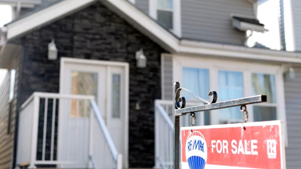 Une maison avec une pancarte à vendre.
